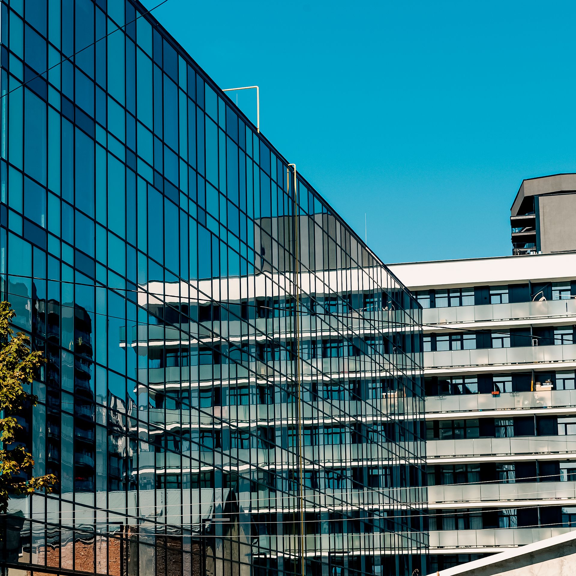 Modern urban buildings reflected in a glass facade